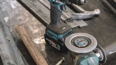 green Makita cordless drill near angle grinder