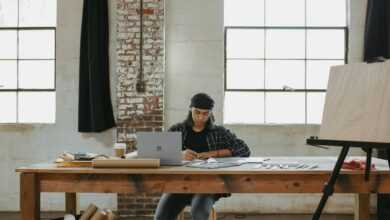 a man sitting at a table working on a laptop