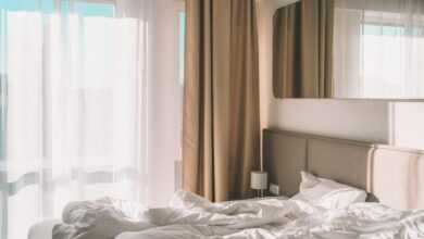 white bed linen near white window curtain