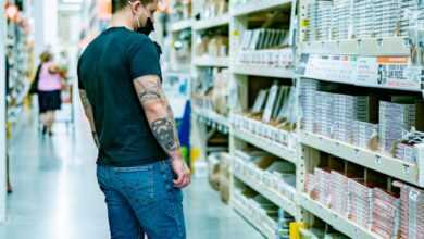 a man standing in a store aisle looking at items