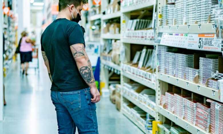 a man standing in a store aisle looking at items