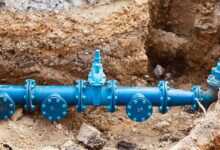 a blue pipe laying on top of a pile of dirt