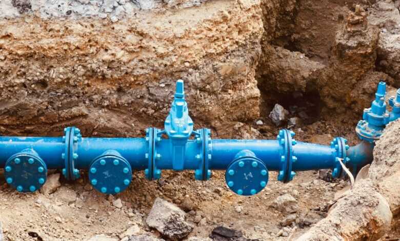 a blue pipe laying on top of a pile of dirt