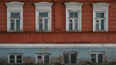 an old building with windows and a stop sign in front of it