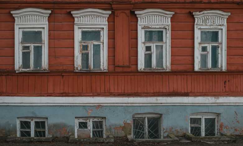 an old building with windows and a stop sign in front of it